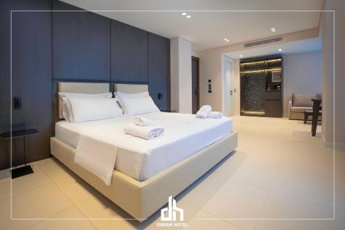 a bedroom with a large white bed with towels on it at DREAM HOTEL SARANDA in Sarandë