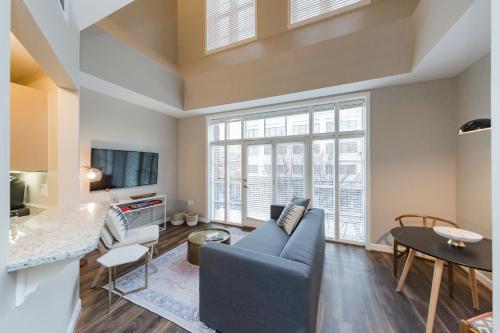 a living room with a blue couch and a large window at Mint House Nashville - Hillsboro Village in Nashville