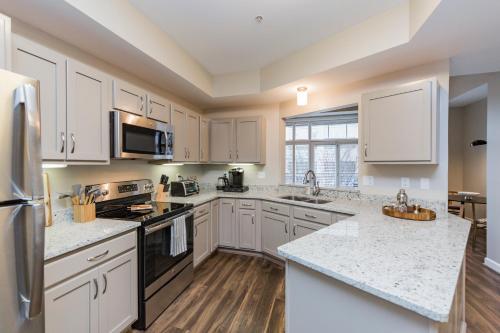 a kitchen with white cabinets and granite counter tops at Mint House Nashville - Hillsboro Village in Nashville