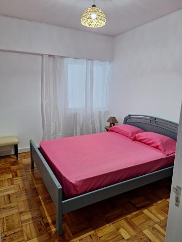 a bedroom with a bed with pink sheets and a window at Casa da Avó Teresa in Porto Santo