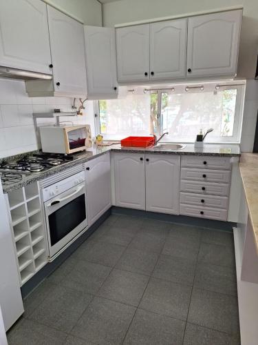 a kitchen with white cabinets and a stove top oven at Casa da Avó Teresa in Porto Santo