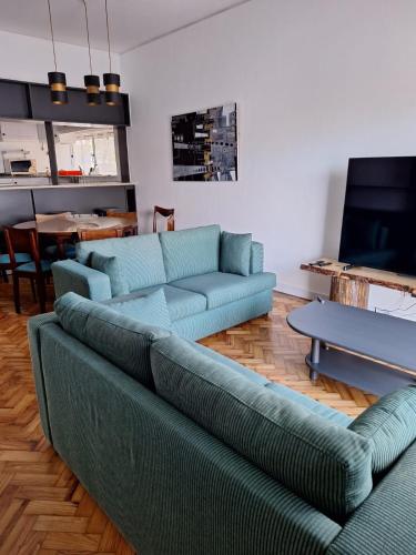 a living room with a blue couch and a table at Casa da Avó Teresa in Porto Santo
