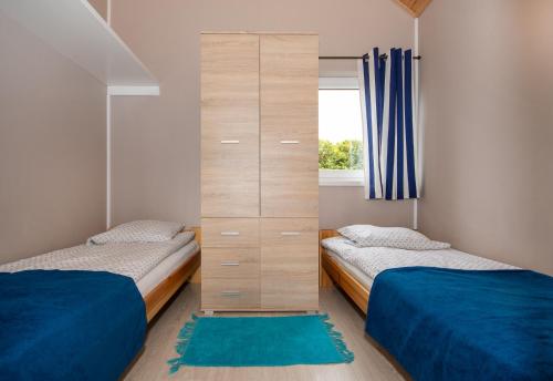 德布吉Domki u Grażyny的有两张床和一个书架的卧室