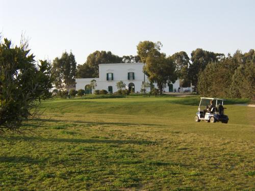 a golf cart in a field in front of a house at Golf Club Metaponto in Metaponto