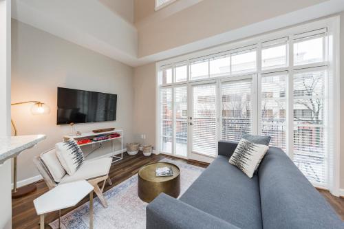 a living room with a blue couch and a tv at Mint House Nashville - Hillsboro Village in Nashville