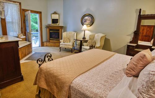 a bedroom with a large bed and a fireplace at Rockwell Falls Inn and Wine Bar in Lake Luzerne