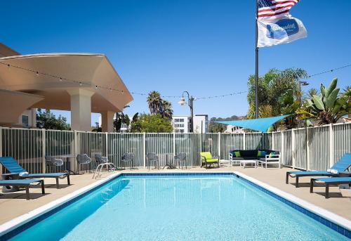 a swimming pool with chairs chairs and an american flag at Hampton Inn San Diego/Del Mar in San Diego