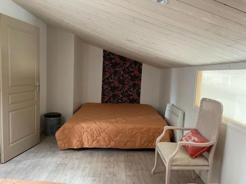 una camera da letto con un letto, una sedia e una finestra di Le logis des Lilas a Corme-Royal