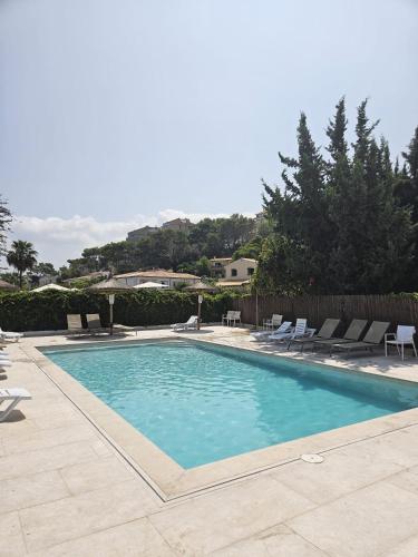 a large swimming pool with chairs at Beautiful Apartment in Pollença Gotmar in El Port
