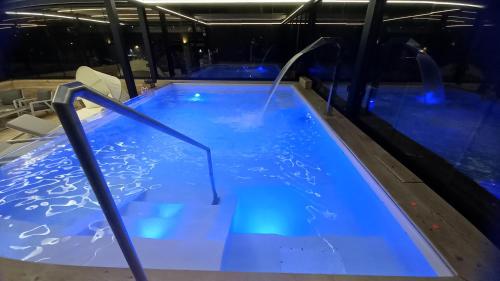 a hot tub with blue water and chairs in it at Hotel Giardino in Bibbiena