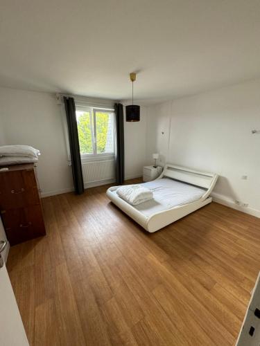 - une grande chambre avec un lit et du parquet dans l'établissement Joli Appartement, à Saint-Martin-des-Champs