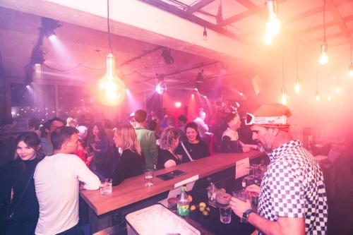 a group of people sitting at a bar in a room at Story Thusis in Thusis