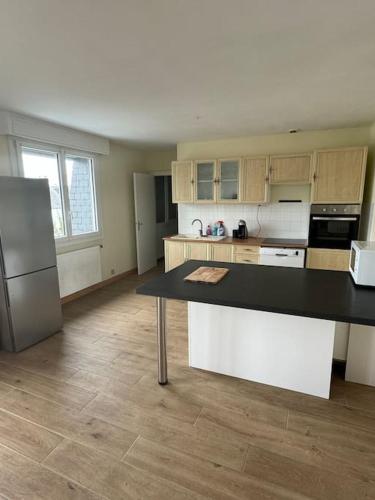 une cuisine avec un comptoir noir dans une pièce dans l'établissement Joli Appartement, à Saint-Martin-des-Champs