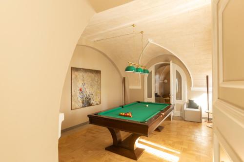 a pool table in a room with an arched ceiling at Borgo Dei Conti Resort Relais & Chateaux in Monte Petriolo