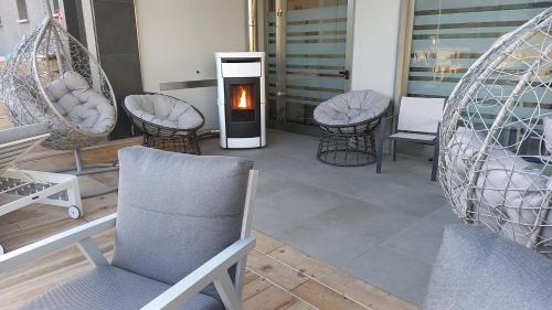 a room with chairs and a fireplace on a porch at Hotel Giardino in Bibbiena