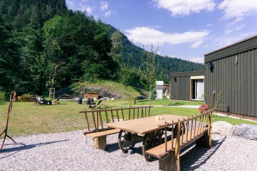 a wooden picnic table sitting next to a field at Story Thusis in Thusis