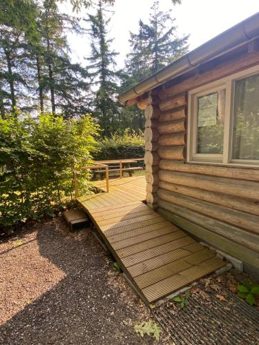 a wooden deck on the side of a cabin at Knus boomstamhuisje op de Schatberg - nabij Toverland in Sevenum