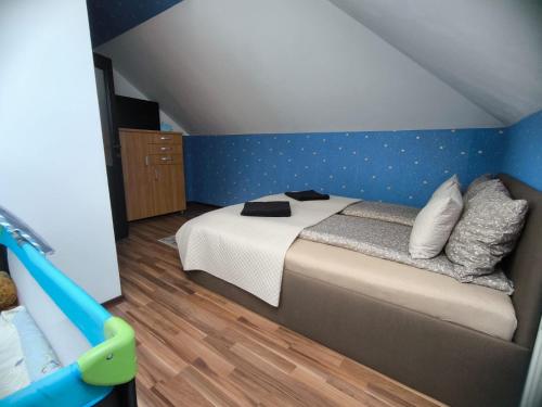 a bedroom with a bed with a blue wall at Morrison Rezidence in Miercurea-Ciuc