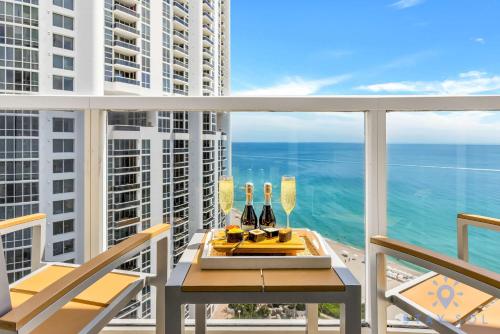 a balcony with a table with wine bottles and chairs at Ocean View Luxurious Studio Premium Amenities in Sunny Isles Beach