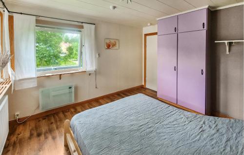 a bedroom with a purple bed and a window at 2 Bedroom Nice Home In Ankarsrum in Ankarsrum