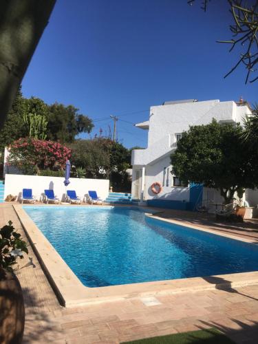 a swimming pool in front of a house at Lugar das Andorinhas in Albufeira