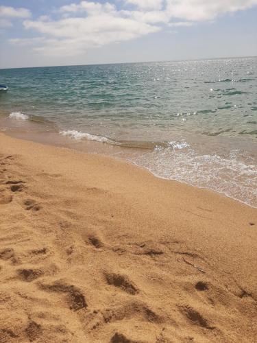 a beach with footprints in the sand and the ocean at Il Rifugio del Conte in Torre Dei Corsari