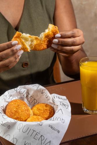 a person eating a piece of food in a basket at Ipanema Inn Hotel in Rio de Janeiro