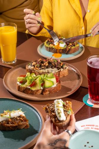 a group of people sitting at a table with plates of food at Ipanema Inn Hotel in Rio de Janeiro