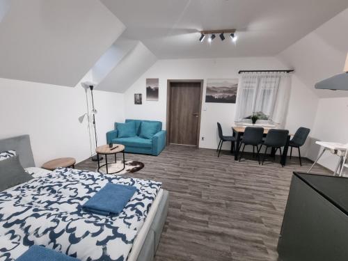 un soggiorno con letto e divano blu di Apartmán Pod Hrází Chráštany a Benešov