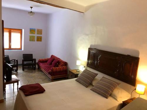 a bedroom with a bed and a living room at Casa Teto, ideal famílies i grups in Bot