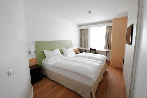 a bedroom with a large white bed and a window at Good Morning Kista in Stockholm