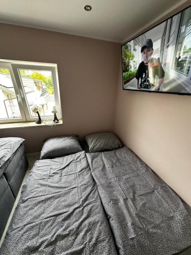 シフィエンタ・カタジナにあるPokój premiumのベッドと壁にテレビが掛かった寝室