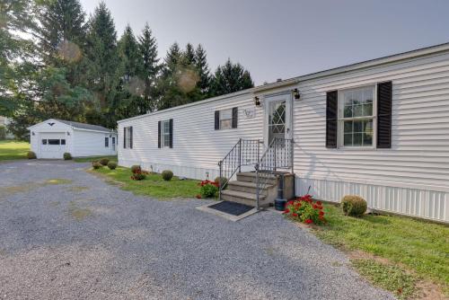 a white house with a staircase next to a driveway at Quaint Lakemont Retreat 1 Mi to Seneca Lake! in Lakemont