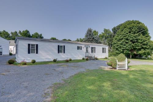 a white house with a fence in a yard at Quaint Lakemont Retreat 1 Mi to Seneca Lake! in Lakemont