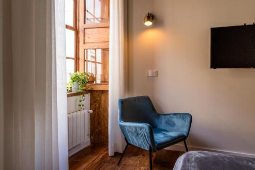 a blue chair in a room with a window at Laguna Cool Living in La Laguna