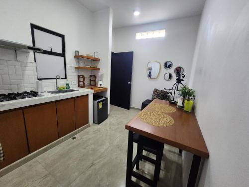 a kitchen with a table and a counter in a room at Amazonia Deluxe Calle 13 in Leticia