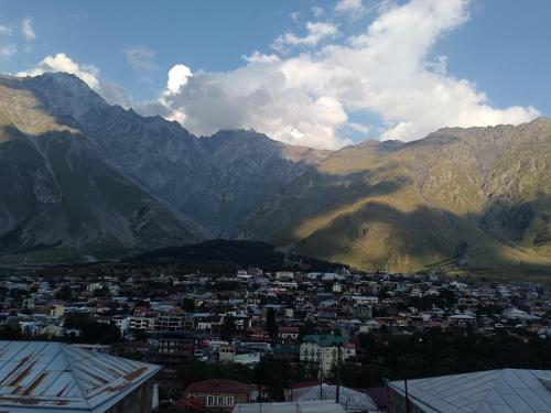 a city in front of a mountain range at My house in Stepantsminda