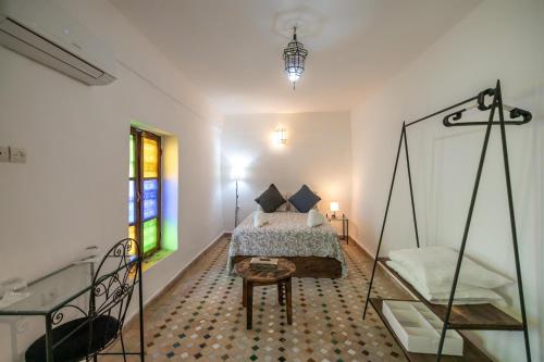 a bedroom with a bed and a table at Riad Nashira in Fès