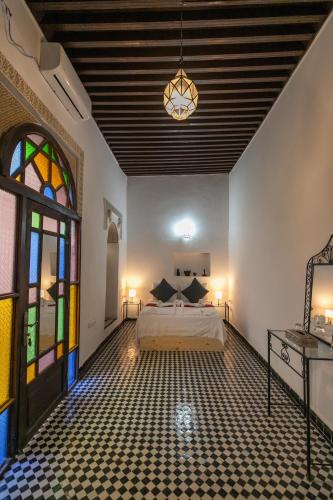 a bedroom with a bed and a stained glass window at Riad Nashira in Fès