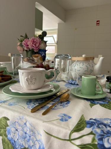 a table with cups and saucers on a table at Casa da Lara in Lagoa