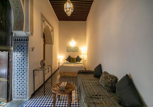 a living room with a couch and a bed at Riad Nashira in Fès