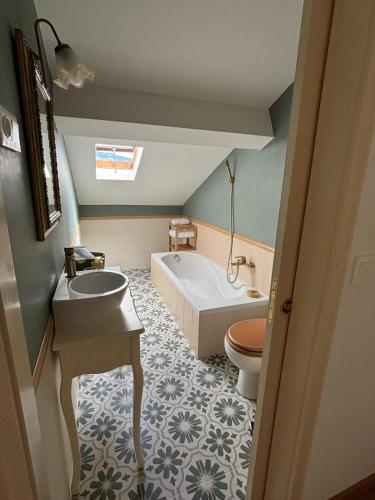 a bathroom with a tub and a sink and a toilet at Casa da Lara in Lagoa