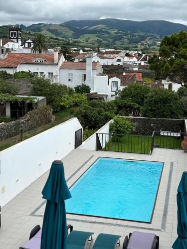 a swimming pool on a patio with chaise lounge chairs at Casa da Lara in Lagoa