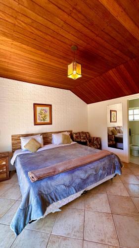a bedroom with a large bed with a wooden ceiling at La Vita Pousada de Charme in Campos do Jordão