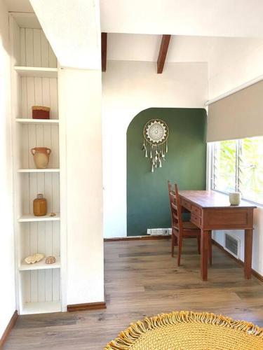 a dining room with a table and a green wall at Patraka - 'No worries' in Rivière Noire