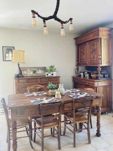 a dining room with a wooden table and chairs at Charme et confort en Isère in Saint-Siméon-de-Bressieux
