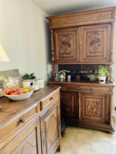 a kitchen with wooden cabinets and a bowl of fruit at Charme et confort en Isère in Saint-Siméon-de-Bressieux
