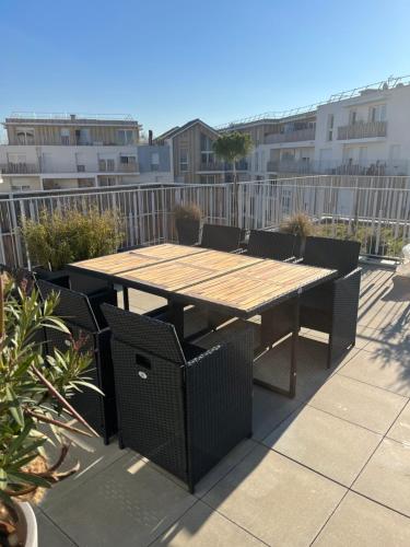 une table et des chaises en bois sur une terrasse dans l'établissement Stade Nautique Vaires sur Marne, à Vaires-sur-Marne