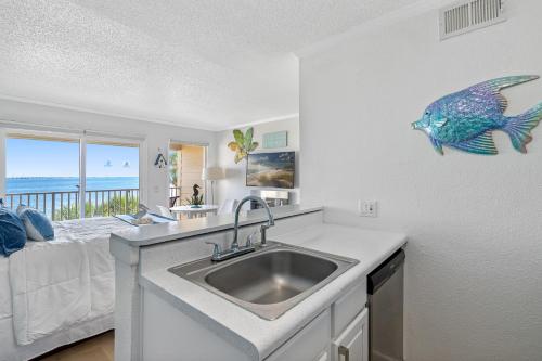 eine Küche mit einem Waschbecken und ein Schlafzimmer mit einem Bett in der Unterkunft Fun-N-Sun with Spectacular Ocean Views in Tampa