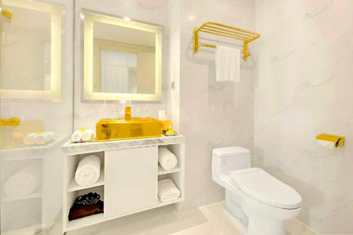 a white bathroom with a sink and a toilet at Golden Apartment in Da Nang Bay in Danang